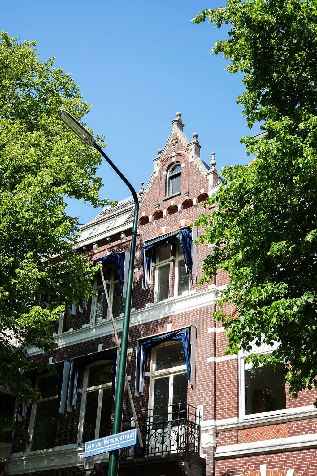 Gevel van Jan van Nassaustraat 113 met bomen op de voorgrond